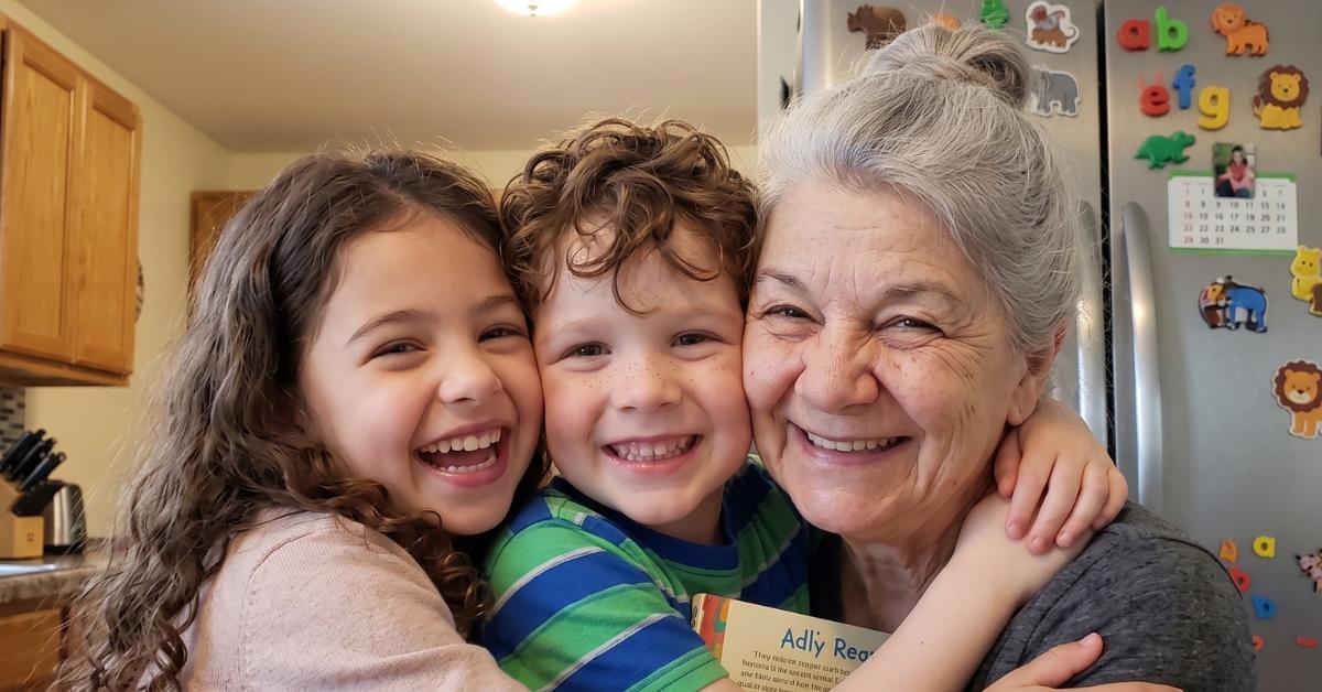 A warm smartphone photo of the grandmother hugging her granddaughter Lea and grandson Felix, all smiling joyfully together